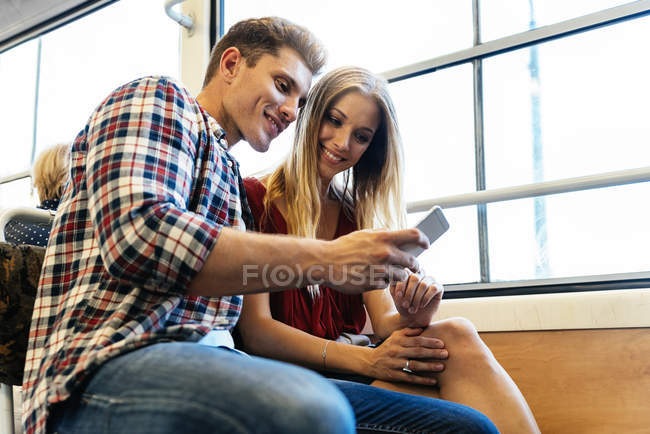 Портрет молодой пары с помощью мобильного телефона на улице . — стоковое фото