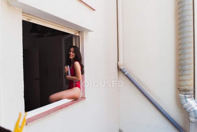 Girl sitting on window sill — Stock Photo