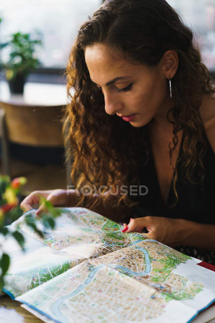 Mädchen im Café liest Karte — Stockfoto
