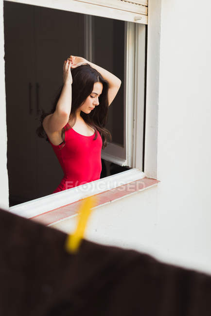 Menina gentil de pé na janela — Fotografia de Stock