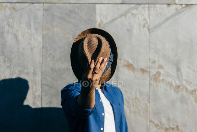 Чоловік закриває обличчя капелюхом — стокове фото