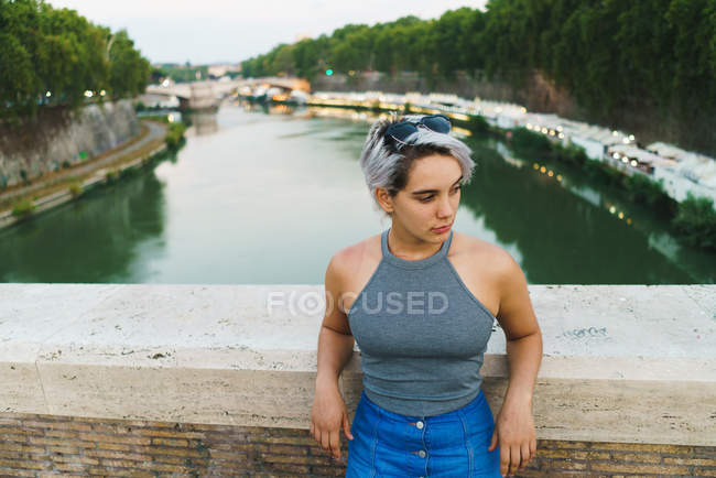Jeune femme confiante posant sur le pont — Photo de stock