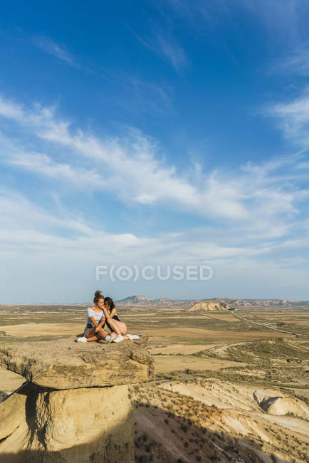 Возбужденные женщины лежат на скале — стоковое фото