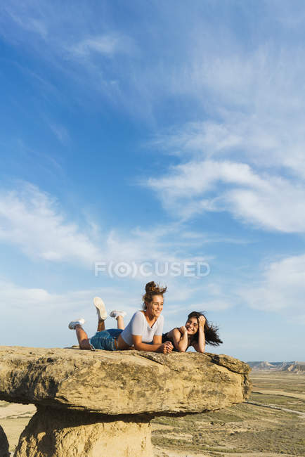 Mujeres emocionadas tumbadas en el acantilado - foto de stock