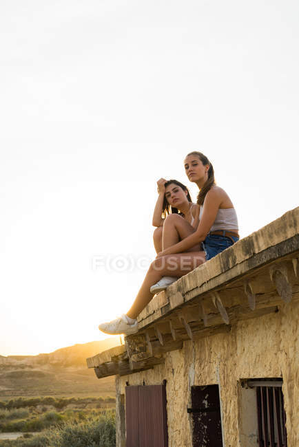 Красивые женщины сидят на крыше — стоковое фото