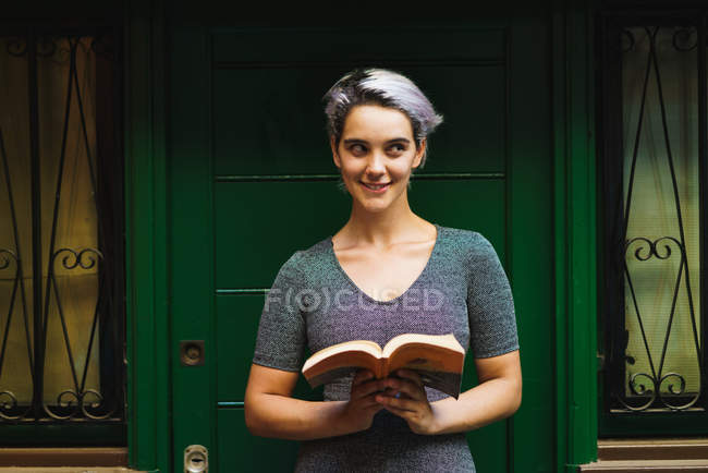 Menina brincalhão posando com livro — Fotografia de Stock