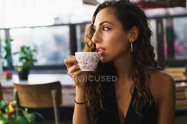 Mujer relajante en la cafetería mientras viaja - foto de stock
