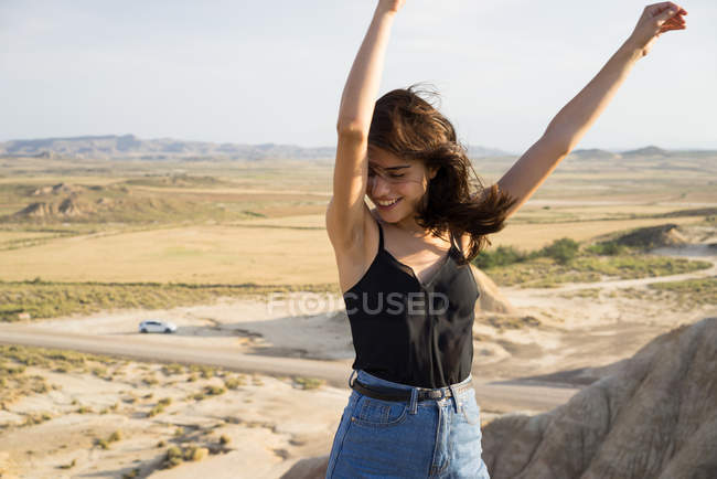 Mujer emocionada de pie en la colina - foto de stock