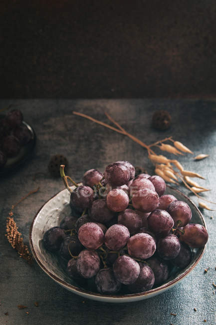 Uvas roxas em uma tigela . — Fotografia de Stock