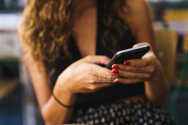 Обрізати дівчину в кафе з телефоном — стокове фото