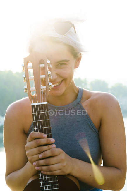 Girl posing with small guitar at street — Stock Photo