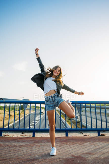 Woman jumping on bridge — Stock Photo
