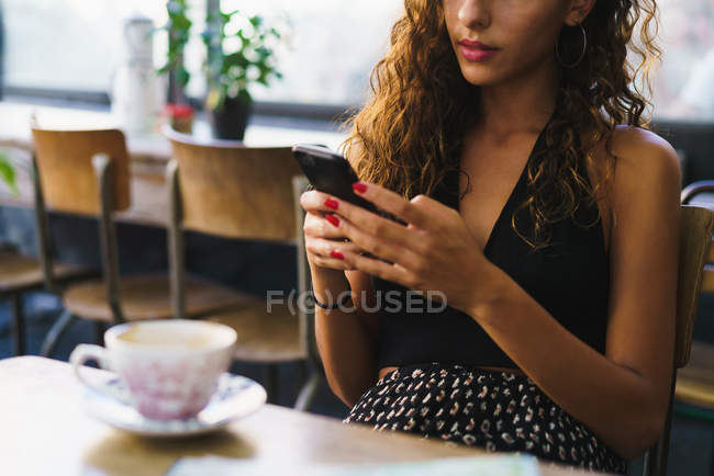 Mädchen mit Handy im Café — Stockfoto