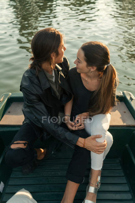 Hohe Winkel der Umarmung Paar sitzt auf dem Boot und schaut über die Schulter — Stockfoto