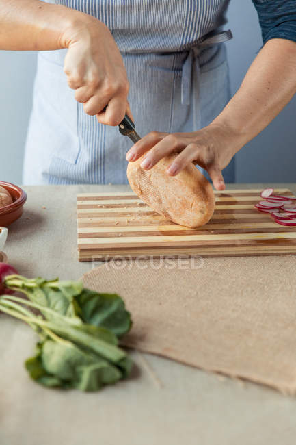 Кухар нарізає хлібну булочку — стокове фото