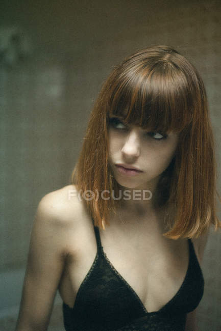 Portrait of young girl in black bra looking away — Stock Photo