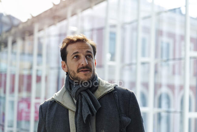 Jeune homme à la station illuminé par la lumière du soleil à travers le windo de verre — Photo de stock