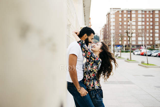Пара спирається на стіну на вулиці — стокове фото