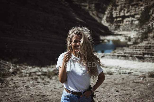 Усміхнена блондинка стоїть біля озера — стокове фото