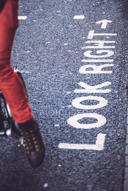Ciclista e testo su asfalto — Foto stock