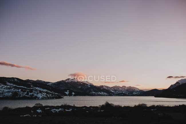 Alba alle montagne con lago sotto il cielo viola . — Foto stock