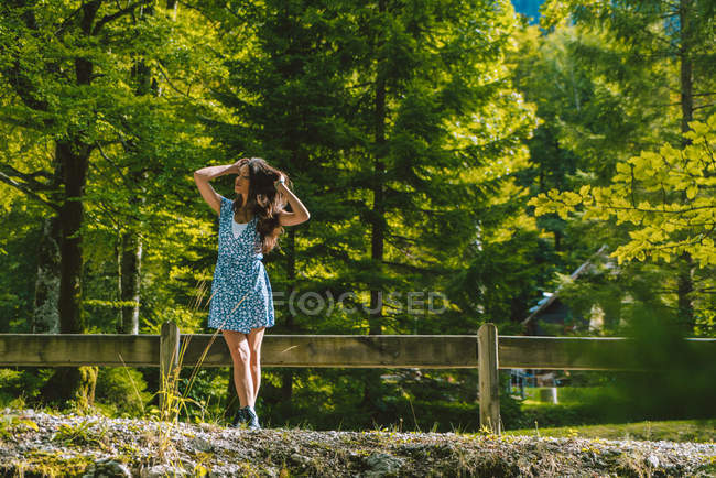 Chica posando cerca de valla de madera - foto de stock