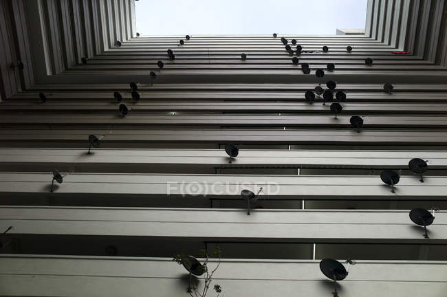 Low angle view of modern building facade with small satellites systems. — Stock Photo