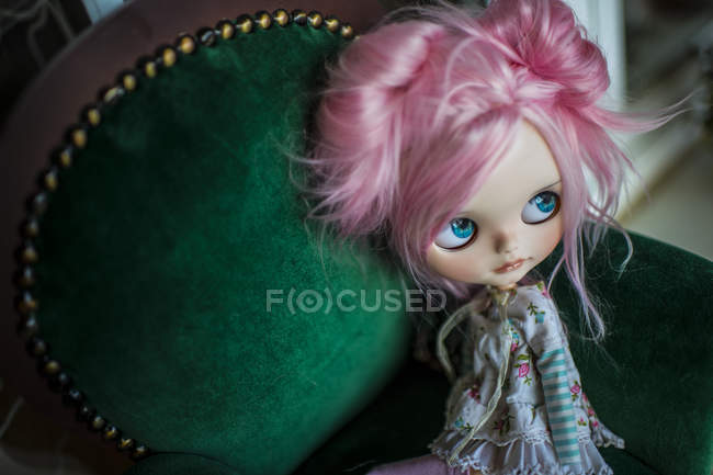 Vista de cerca de la muñeca moderna de pelo rosa en silla vintage - foto de stock