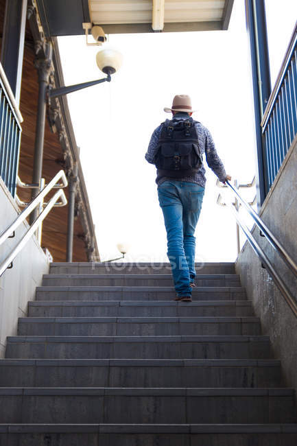 Низкий угол обзора человека, идущего по лестнице станции метро — стоковое фото