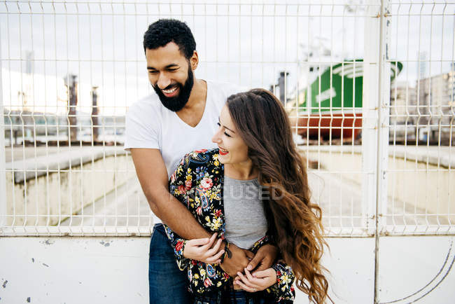 Laughing couple posing near wharf fence — Stock Photo