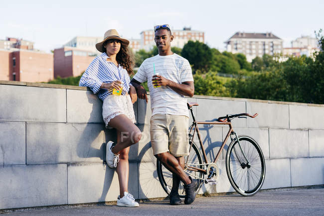 Pareja con bebidas y bicicleta - foto de stock