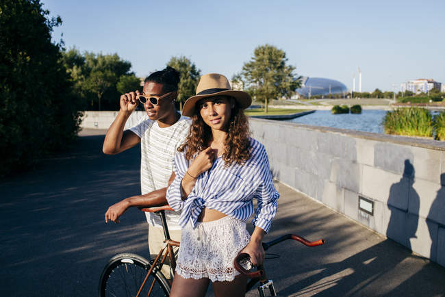 Casal inclinado na bicicleta no parque urbano — Fotografia de Stock
