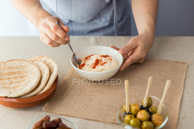 Donna che cucina hummus — Foto stock