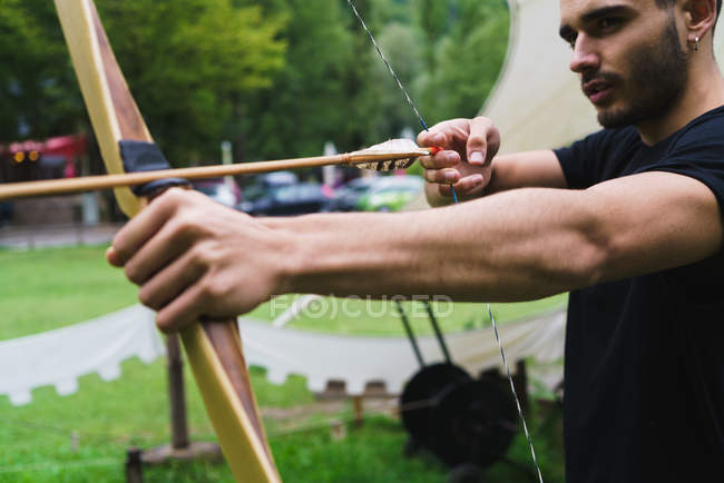 Crop man practicing archery in school — Stock Photo