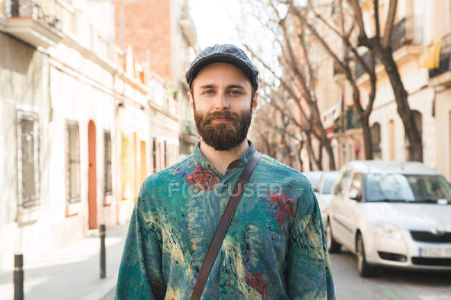 Бородатий весела людина посміхаючись очима на камеру в міській вулиці — стокове фото