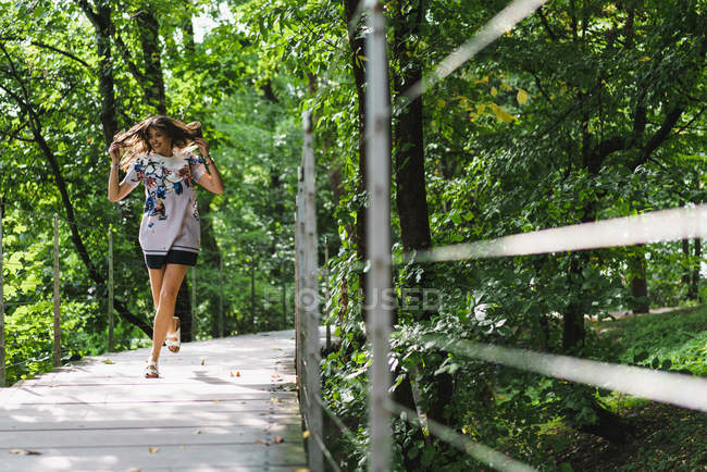 Молодая женщина бежит по набережной в лесу — стоковое фото