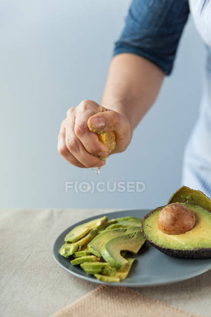 Koch presst Zitrone auf Avocado — Stockfoto