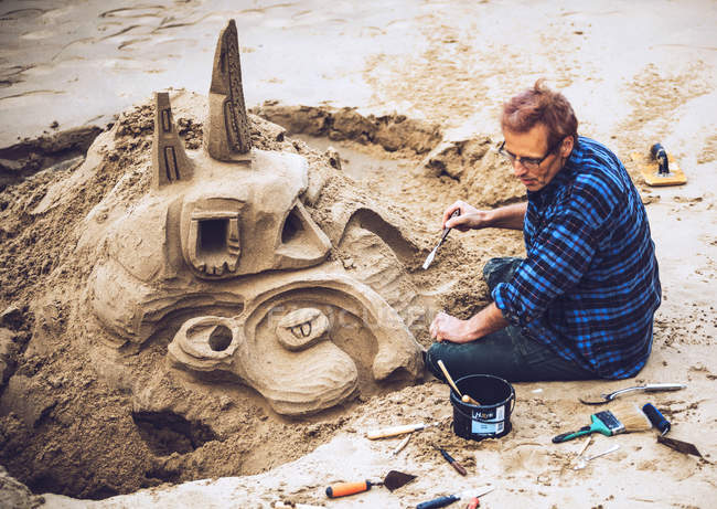 Man building sand castle — Stock Photo