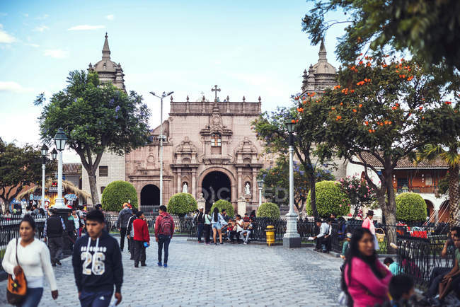 AYACUCHO, PERÚ - 30 DE DICIEMBRE DE 2016: Gente caminando sobre fondo de fachada adornada en la Plaza Mayor de Ayacucho - foto de stock