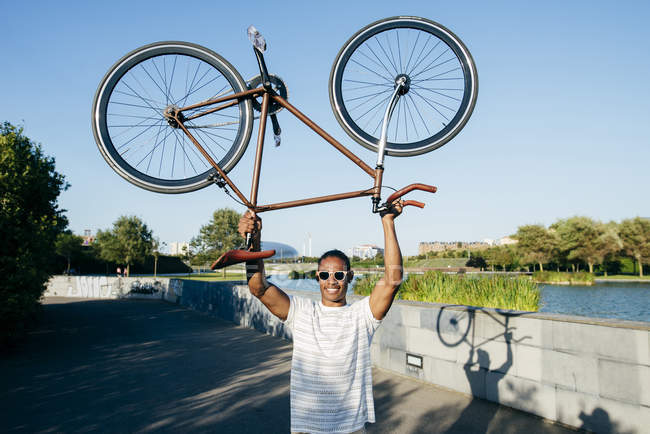 Mann hält Fahrrad über Kopf — Stockfoto