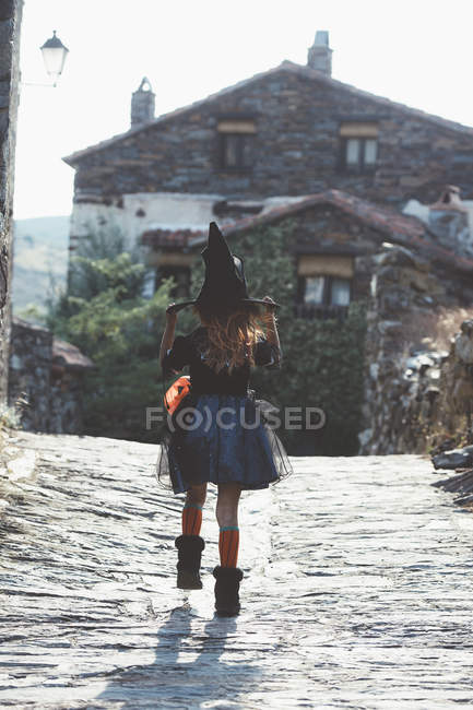 Chica en halloween traje caminando calle - foto de stock