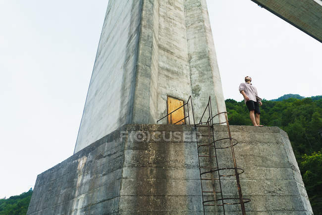 Человек позирует на старой бетонной башне — стоковое фото