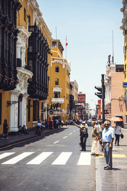 LIMA, PERU - DECEMBER 26, 2016: People walking near crossroad at sunlit street scene — Stock Photo