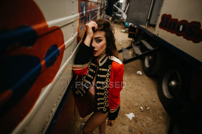 Woman in red coat posing between trailers — Stock Photo