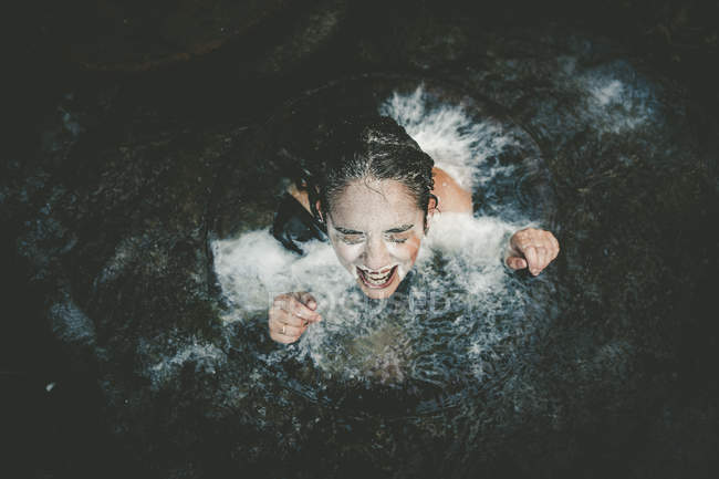 Girl with milk on face swimming out of well — Stock Photo