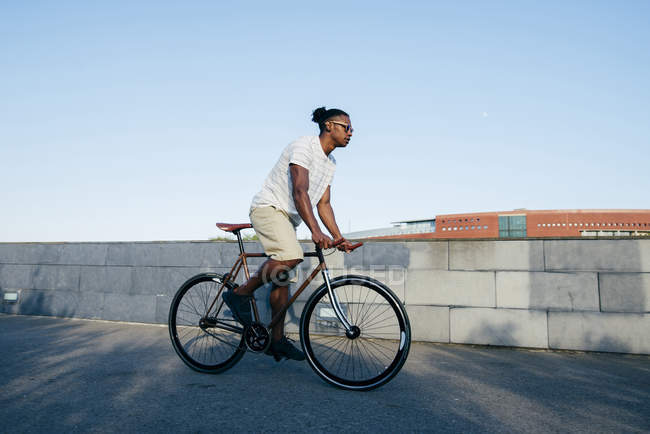 Hombre negro montando bicicleta - foto de stock