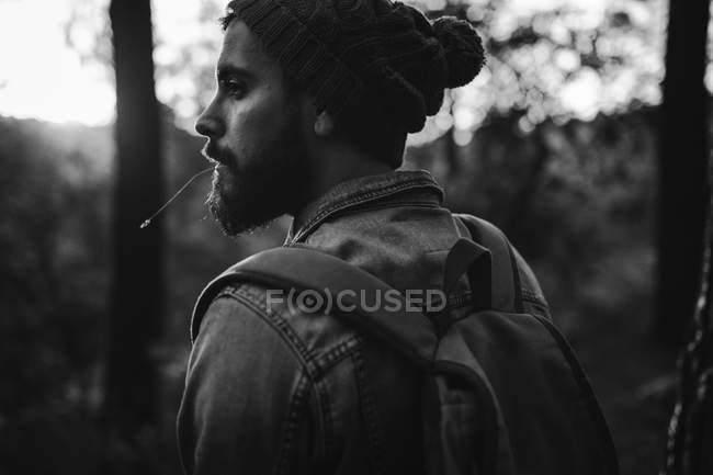 Человек, оглядывающийся через плечо в осеннем лесу — стоковое фото