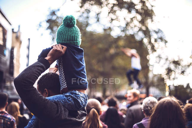 LONDON, UK - OCTOBER 14, 2016: Incognito father holding son on shoulders while standing in crowd on London street. — Stock Photo