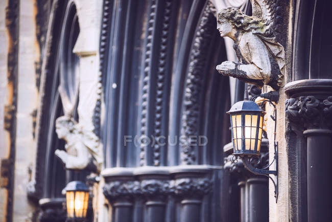 Figurine of angels holding lanterns at arches of church — Stock Photo