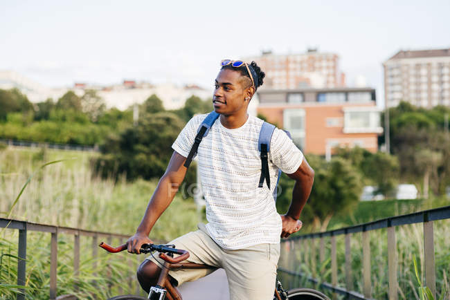 Uomo in posa con bici sul marciapiede — Foto stock